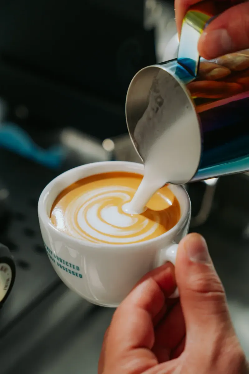 Latte Art wird beim Barista-Kurs in München in einen Cappuccino gegossen