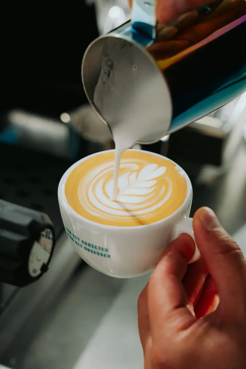 Latte Art wird im Latte-Art-Kurs in München in einen Cappuccino gegossen